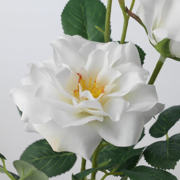 Beautiful artificial white rose with green leaves, made with recycled materials, lifelike and durable.