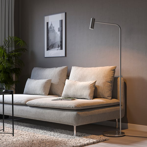 Modern living room with light grey SÖDERHAMN sofa, pillows, floor lamp, rug, and plant.