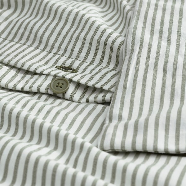 Close-up of a striped shirt button. Shows grey and white stripes with a single button detail.