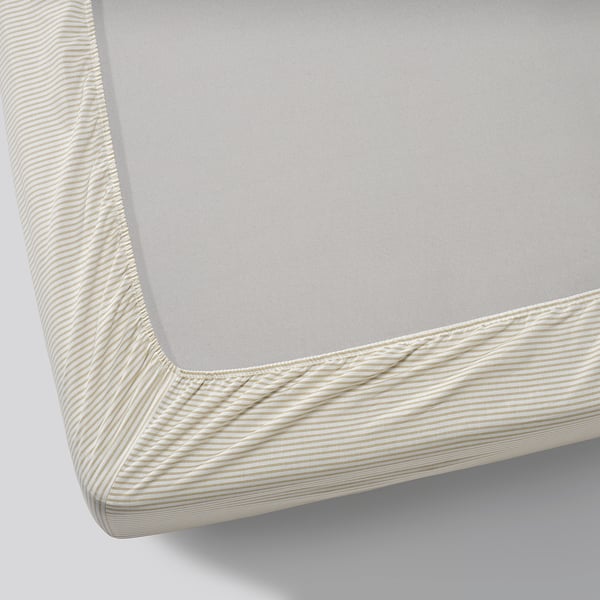 Close-up view of a neatly made bed with a grey fitted sheet and beige striped border, showcasing quality cotton texture.