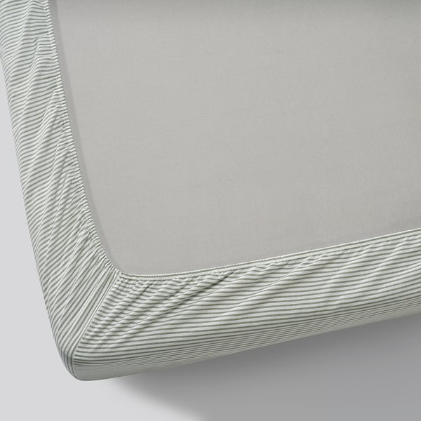 Close-up of high-quality, grey striped cotton mattress sheet, showing intricate texture and secure elastic edge.