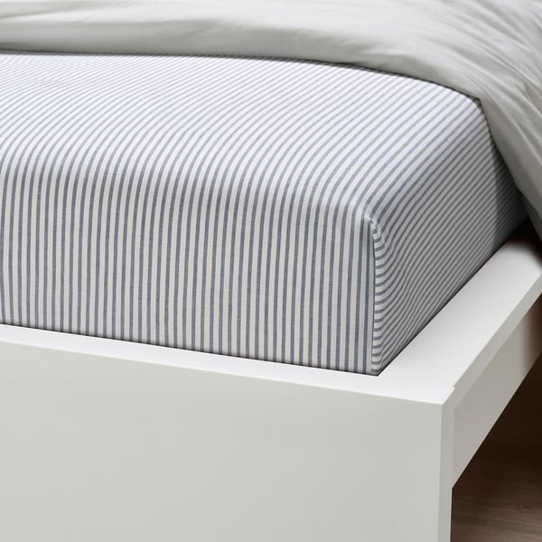 White bed with striped grey sheet, crisp and high-quality.