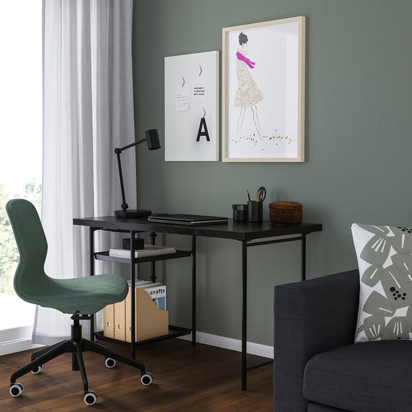 Green corner office with SPÄND table, lamp, art, grey armchair, and large window.