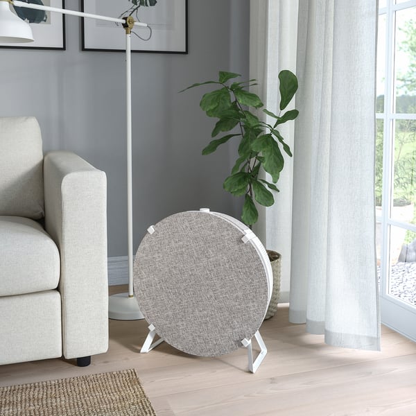STARKVIND air purifier in living room, minimalist, grey, on three legs, neutral decor.