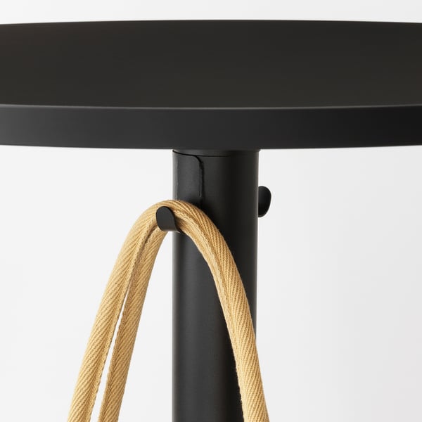 Black round bar table with rope hooks for hanging items.