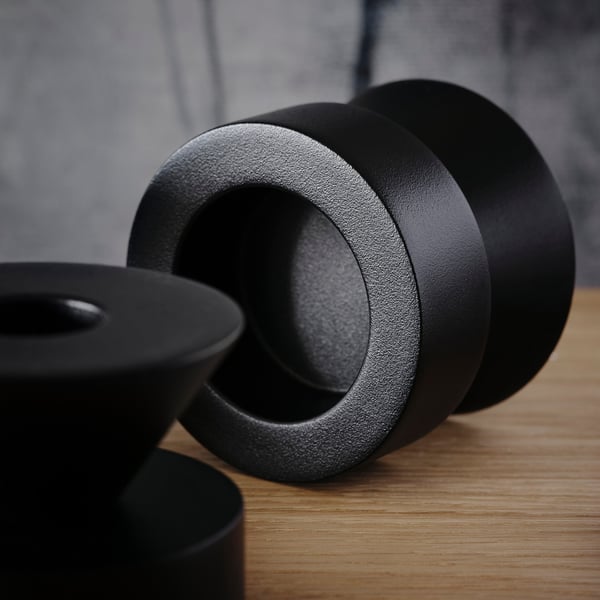 Black metal candlesticks on a wooden surface, showcasing quality craftsmanship and sturdy design.