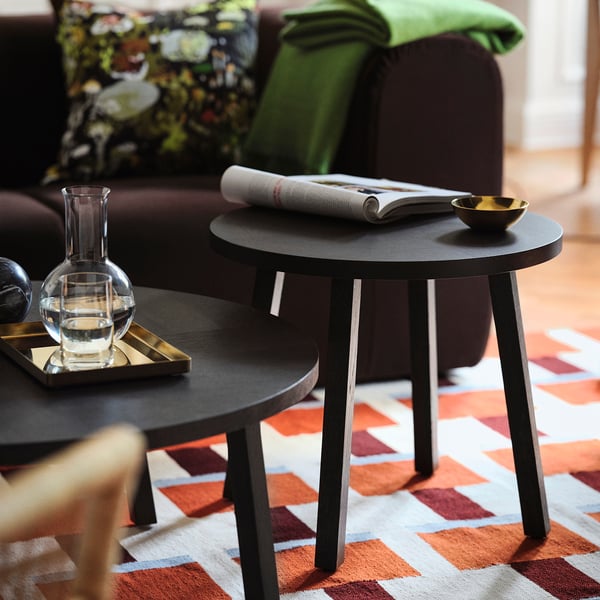 Black oak coffee table near sofa on zigzag rug, 2025 scandinavian design