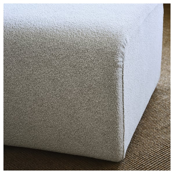 Light grey upholstered sofa corner, showcasing smooth fabric and clean stitching, highlighting quality craftsmanship.