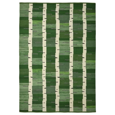 A green handwoven wool rug with a birch tree pattern, reversible, from the stockholm collection.