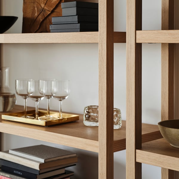 Wooden shelves holding wine glasses, books, and decorative items, securely fixed to the wall.