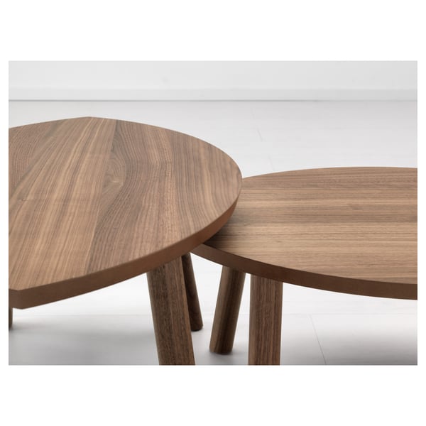 Two stylish, oval wooden nesting tables with smooth, interlocking design; warm, natural wood grain visible.