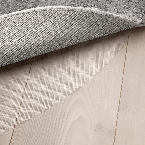 Close-up of rug underside, showing mesh underlay for grip and comfort.