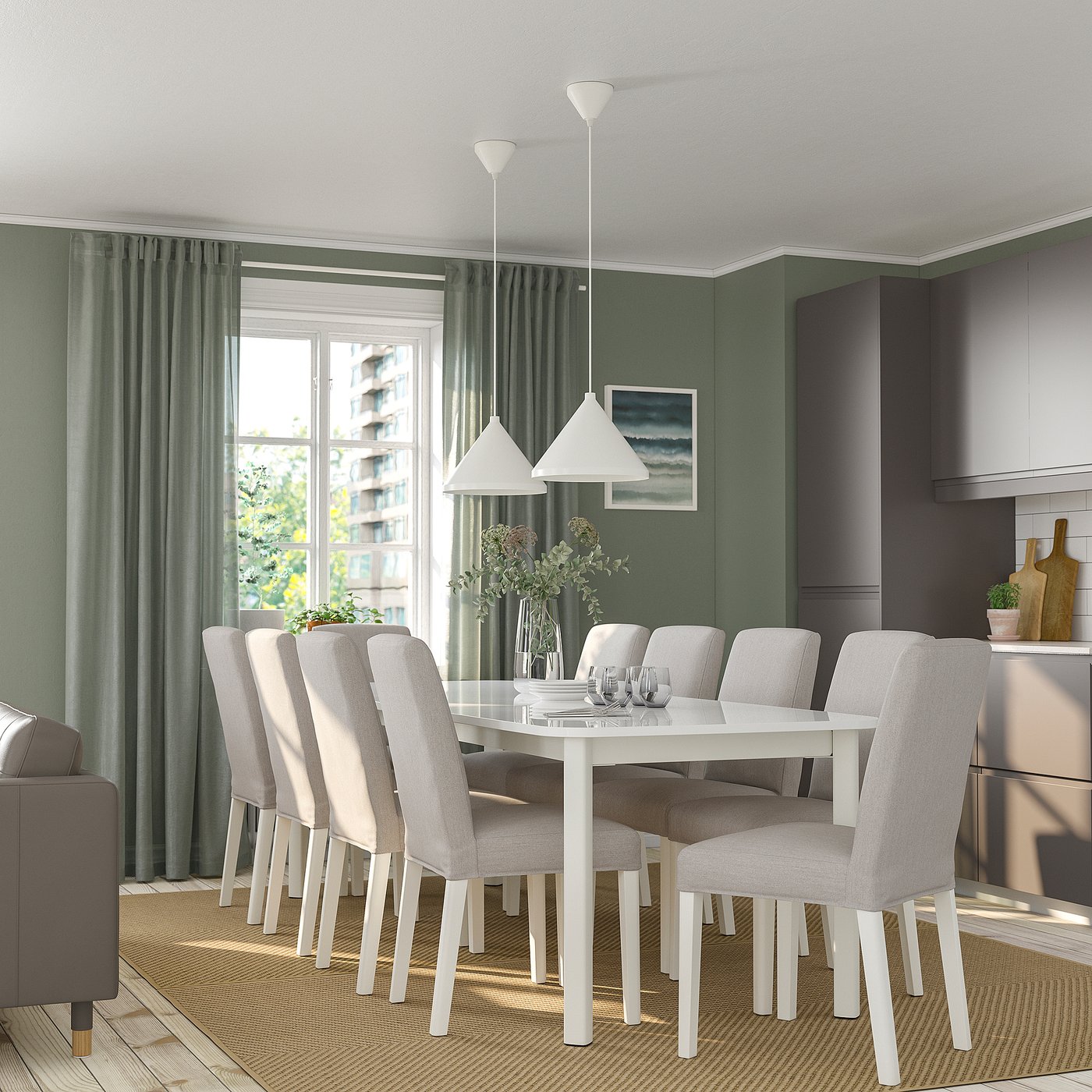Modern dining room with STRANDTORP table, eight beige chairs, green walls, large windows, and hanging lamps.