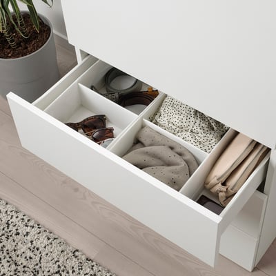 Open white chest of drawers with sock organiser and folded clothing compartments.