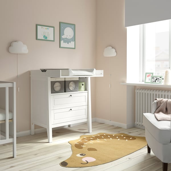 Baby nursery with SUNDVIK dresser, rug, lamps, and crib.