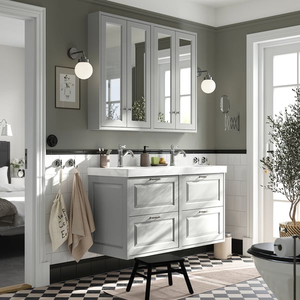 A modern bathroom with a grey TÄNNFORSEN double vanity, featuring mirrored cabinets, double basins, and a sleek design.