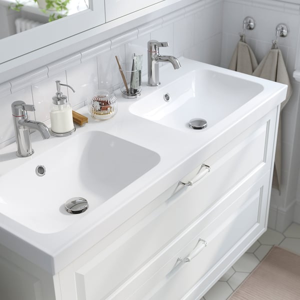 Double-sink vanity with chrome fixtures and storage drawers.