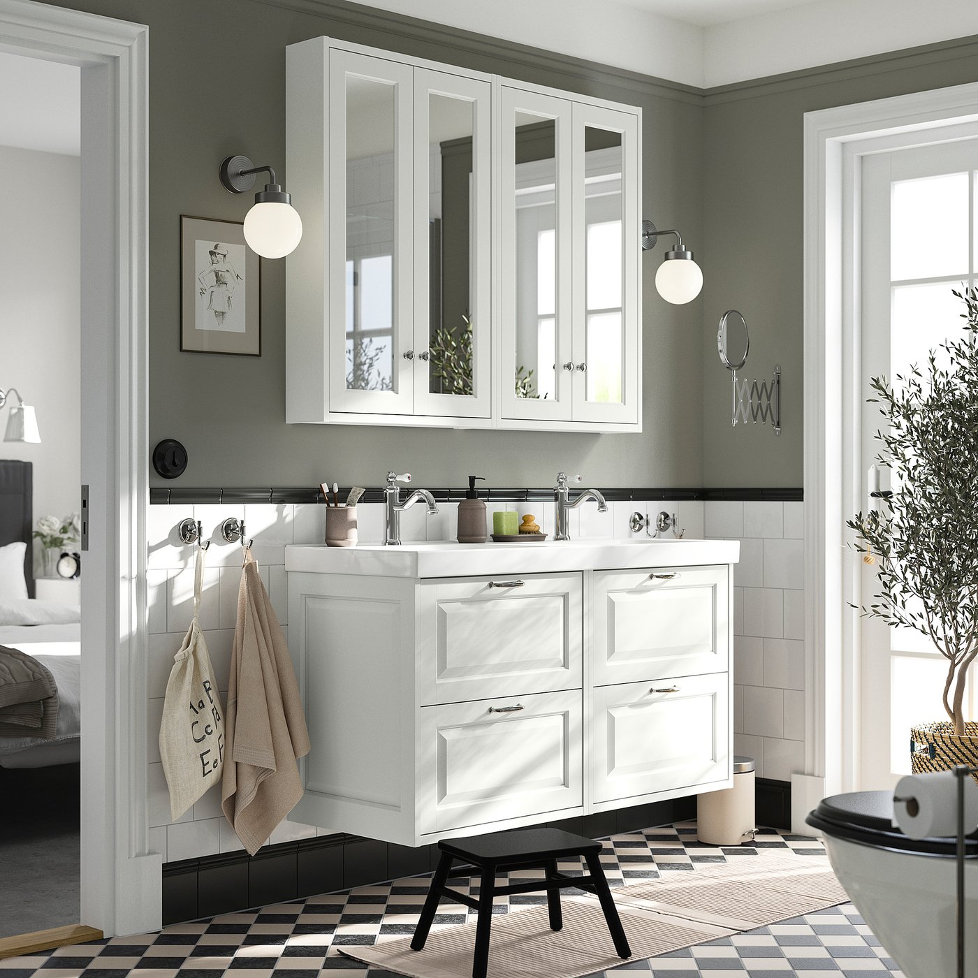 Modern double-sink bathroom vanity in white with mirror cabinet, black-and-white checkerboard floor, green wall, and hanging towels.
