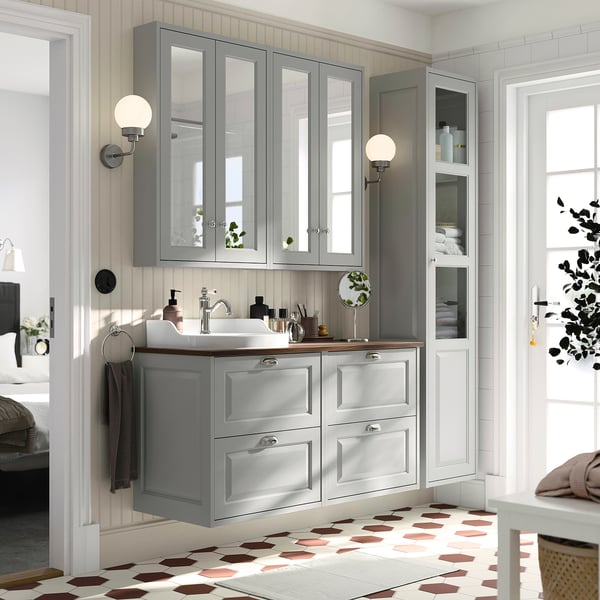 Modern grey bathroom with TÄNNFORSEN double vanity, mirror cabinets, and patterned floor. Sinks and storage surround a spacious countertop.