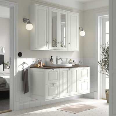 Modern white bathroom cabinet with mirror; countertop, sink, and storage. Large, wall-mounted, sleek design with knobs.