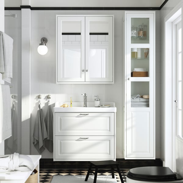 Modern white bathroom with TÄNNFORSEN vanity. Sink, tall cabinet, and towel rack. Classic design with bevelled edges.