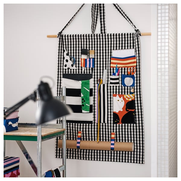 Hanging decorative apron with tool pockets, showcasing a striped pattern and playful cat design.