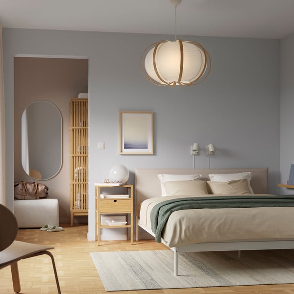 Modern bedroom with blue walls, white bed, green blanket, wood floor, and TAGGTOFS pendant lamp.