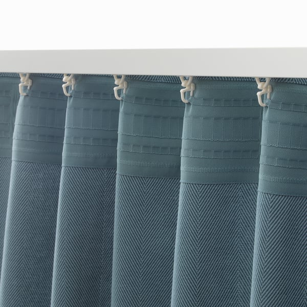 Blue curtains with white tabs for hanging, offering privacy and light dimming.