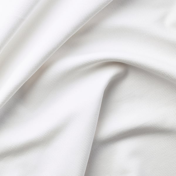 Crisp white fabric with subtle geometric pattern, neatly draped, showcasing quality cotton texture.