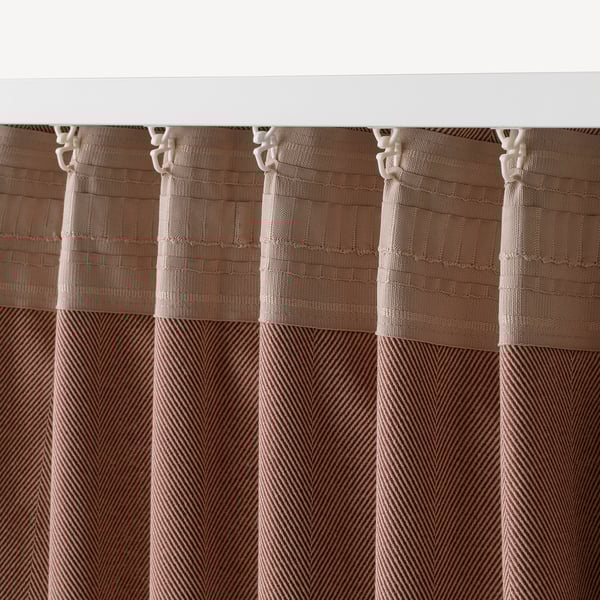 Room-darkening curtains with beige patterned design hang from hooks, blocking light and offering privacy.