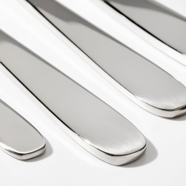 Four polished steel knives, reflecting light, with sleek handles and sharp edges.