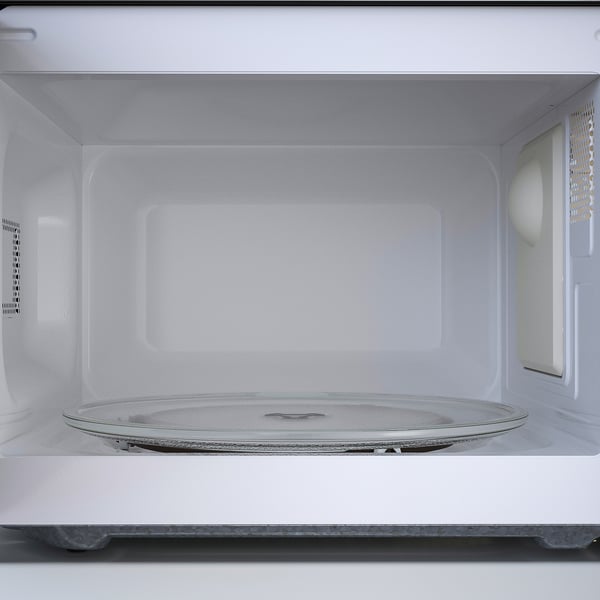 Interior of a compact microwave. A rotating glass turntable, ready to securely hold and heat food evenly.