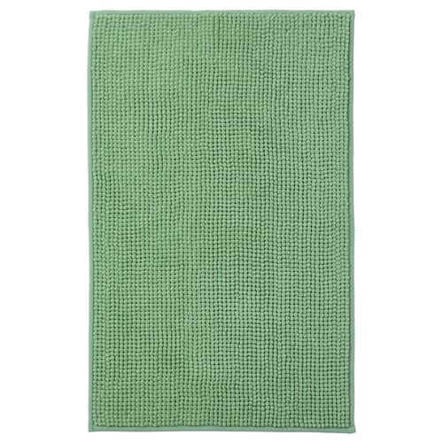 A green TOFTBO bath mat. Its rectangular, soft, and made from recycled polyester with a textured surface.