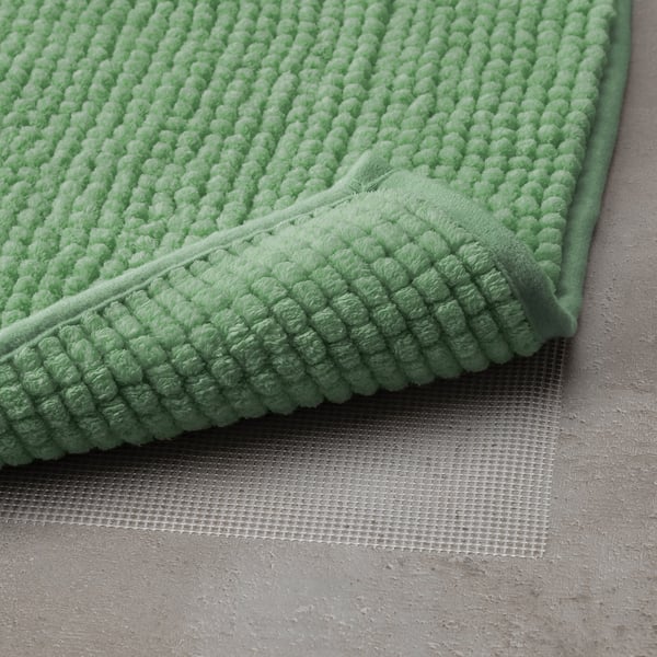 Soft, green bath mat with textured surface ensuring quick dry. Designed for safety and easy cleaning.