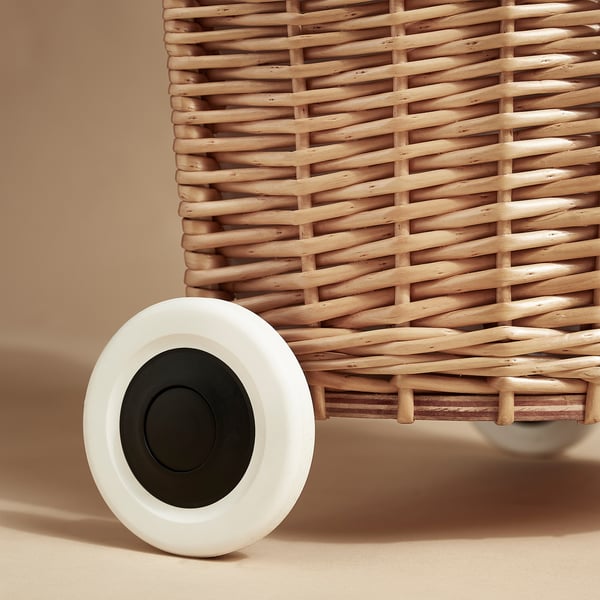 Wicker laundry basket with sturdy, smooth-rolling white wheel. Natural, hand-woven material, durable craftsmanship.