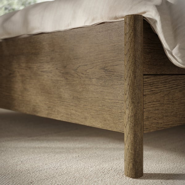 A TONSTAD bed frame with a sleek wooden finish and integrated drawers, emphasising its sturdy and quality construction.