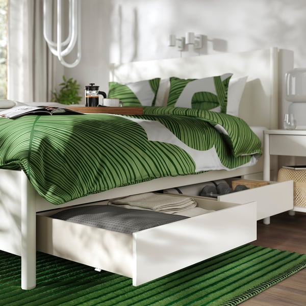 Bed frame with open drawers, green striped bedding. Soft-closing drawers, slatted bed base.