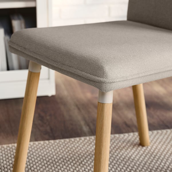 Modern grey chair with sleek wooden legs; comfortable, removable cover.
