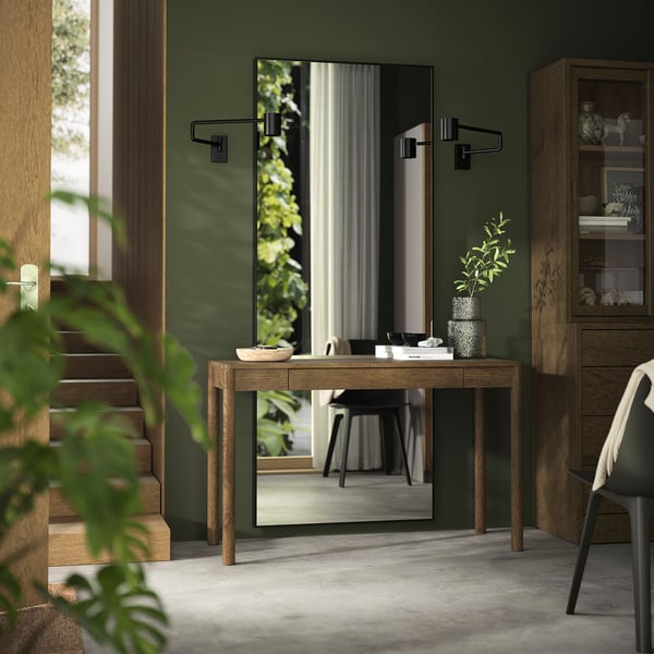 Contemporary hallway with TONSTAD desk, greenery, decor. Framed by stairs, green wall.