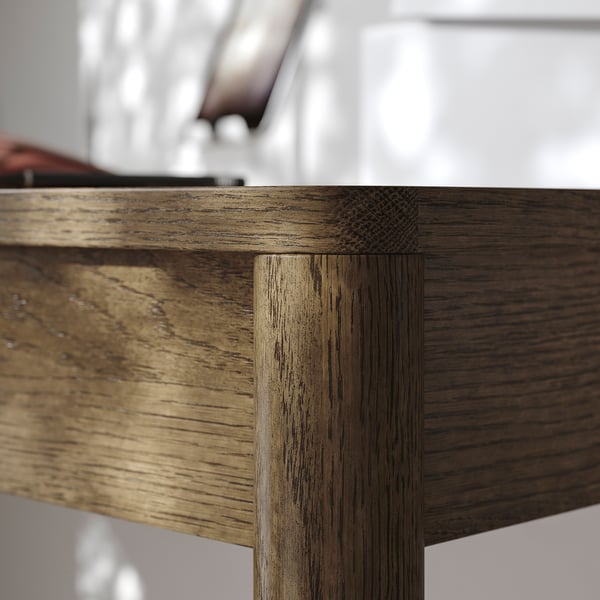 Close-up of a wooden tables corner, showcasing detailed oak veneer texture and precise joinery design.