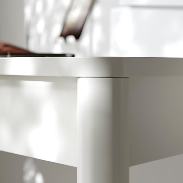 Close-up of a white desks corner, sleek and modern, showcasing smooth edges and high-quality finish.