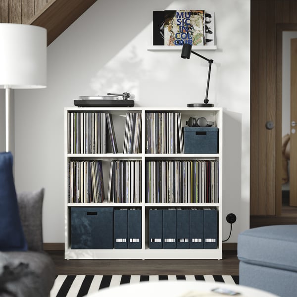 Modern white TONSTAD storage unit with vinyl records, turntable, lamp and books.