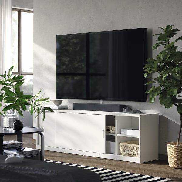 Modern living room with white TONSTAD tv bench, sliding doors, adjustable shelves, and plants.