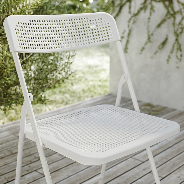 Foldable white plastic chair on deck, part of TORPARÖ set, durable and easy to care for.