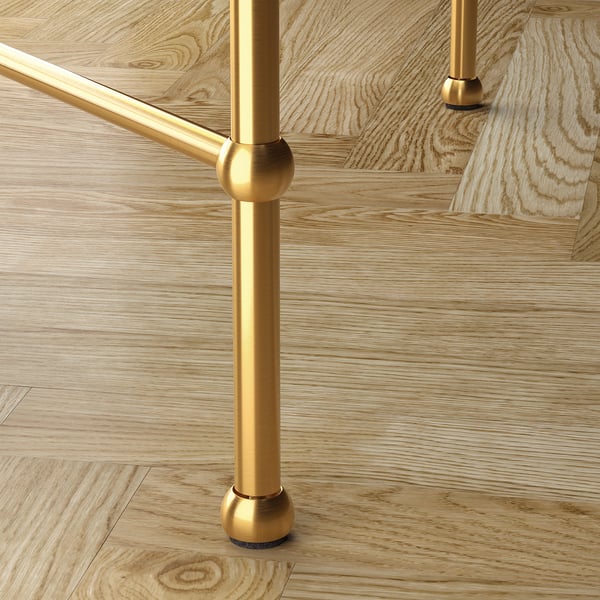 Elegant coffee table with gold metal legs and glass top, showcasing high-quality design and craftsmanship.