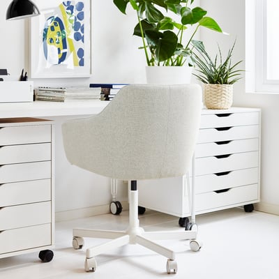 Modern white TOSSBERG office chair between file cabinets in home office.