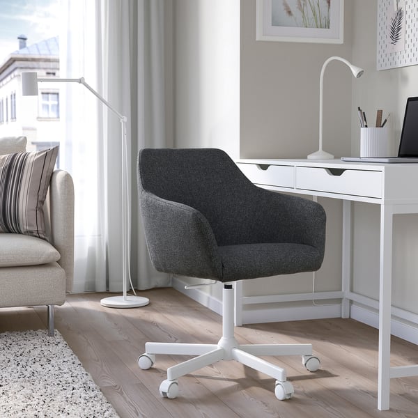 TOSSBERG black fabric swivel chair at desk with laptop.
