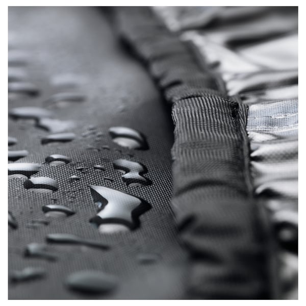 Black-and-white close-up of water beading on a mesh fabric, demonstrating waterproof protection.
