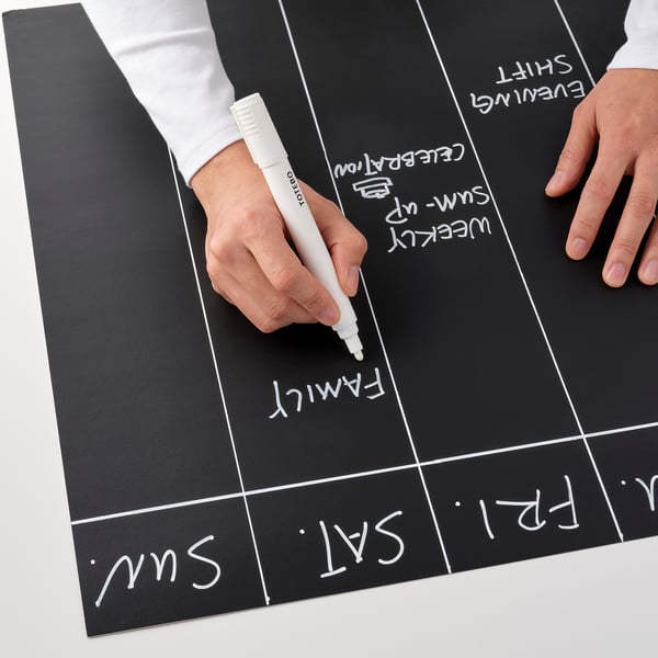 Person writes weekly calendar on blackboard with TOTEBO marker.