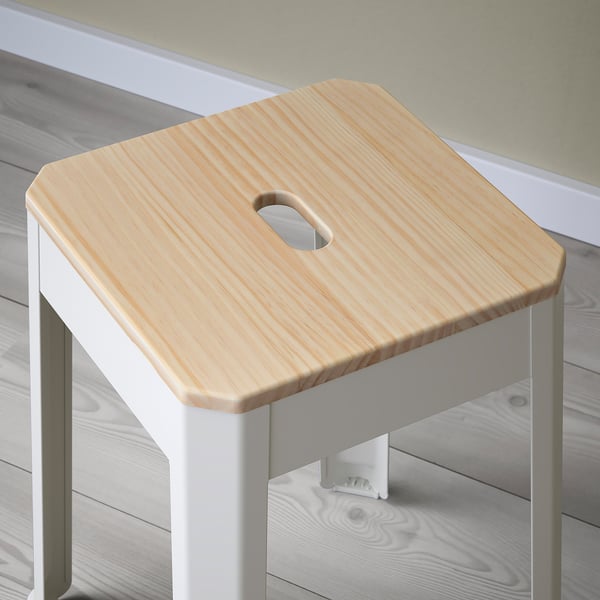 Single wooden stool with light finish, round cutout for handle, and white metal legs. Simple, sturdy, functional design.